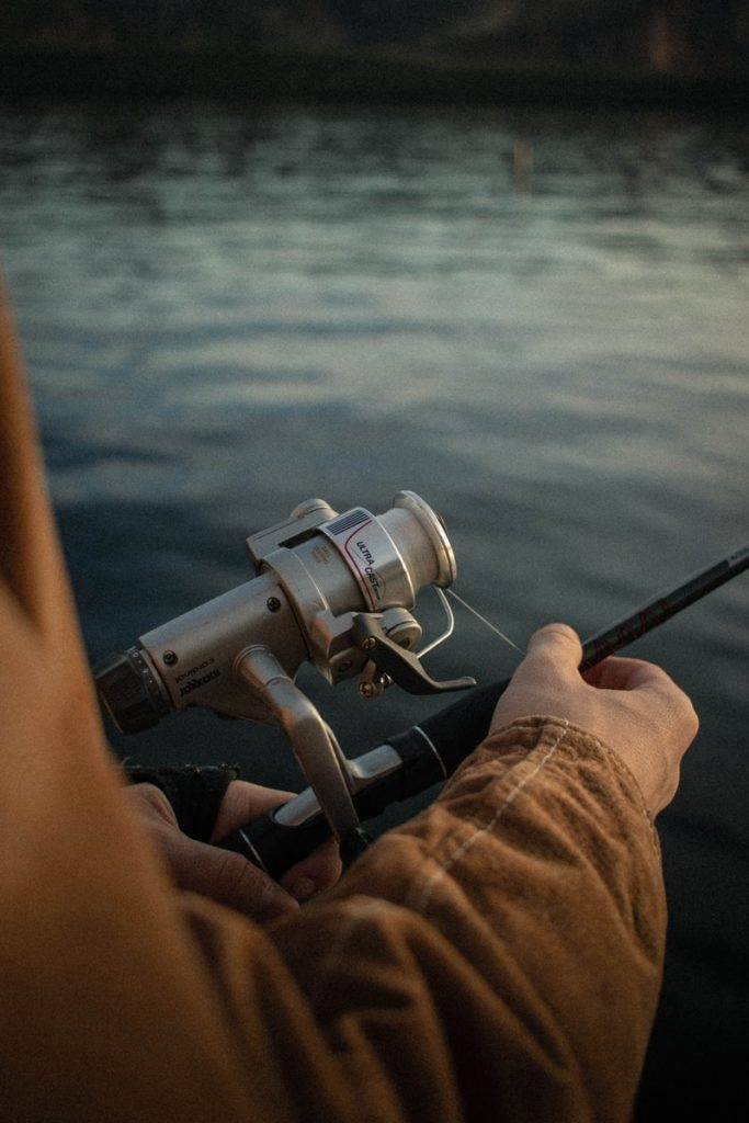 person in brown pants and black and gray fishing rod